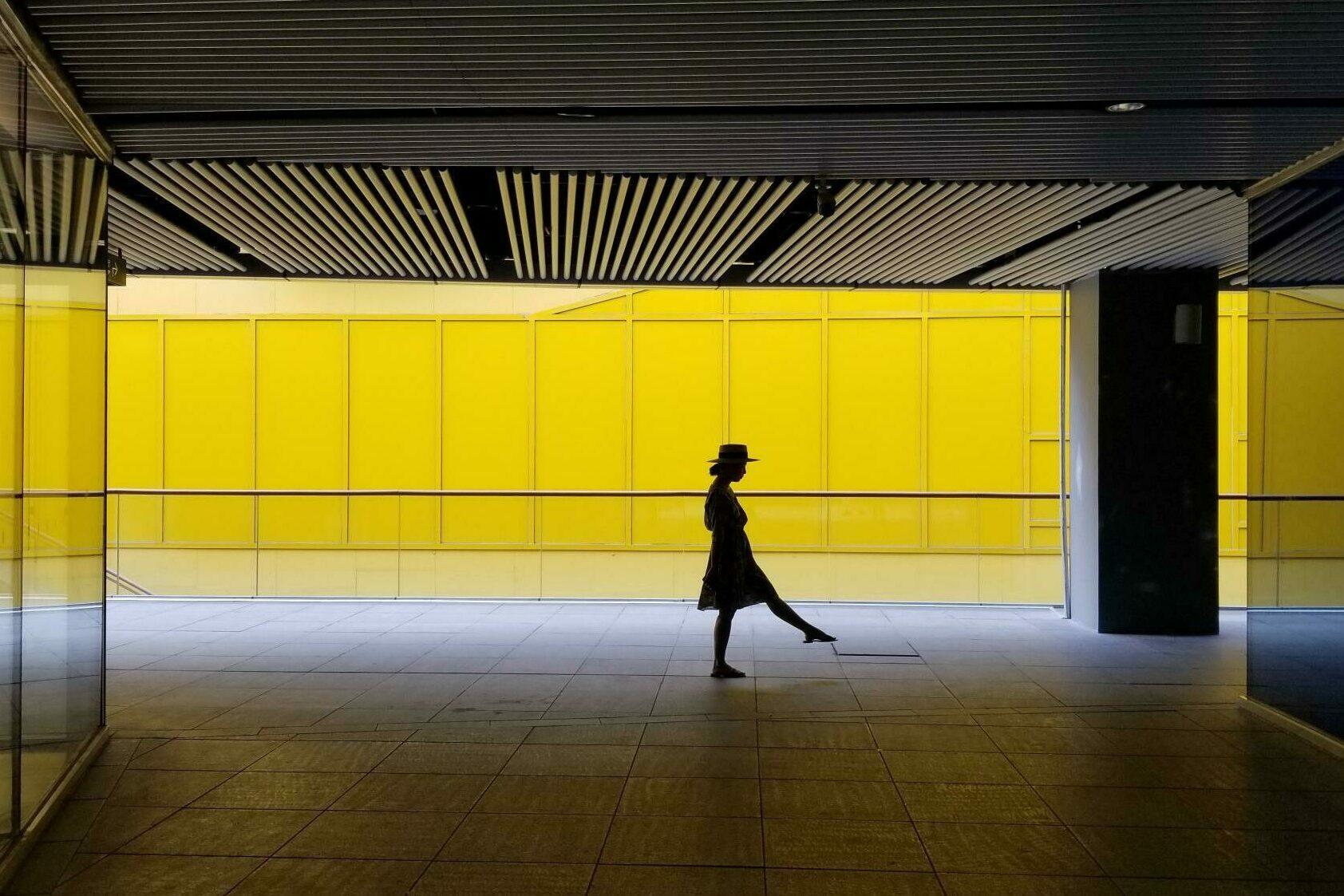 Silhouette einer Frau in einer gelben U-Bahn.