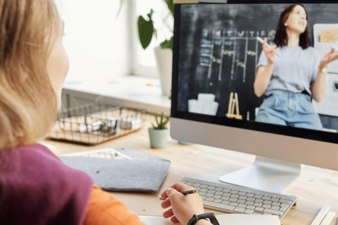 Mädchen sitzt vor Laptop und lernt online.